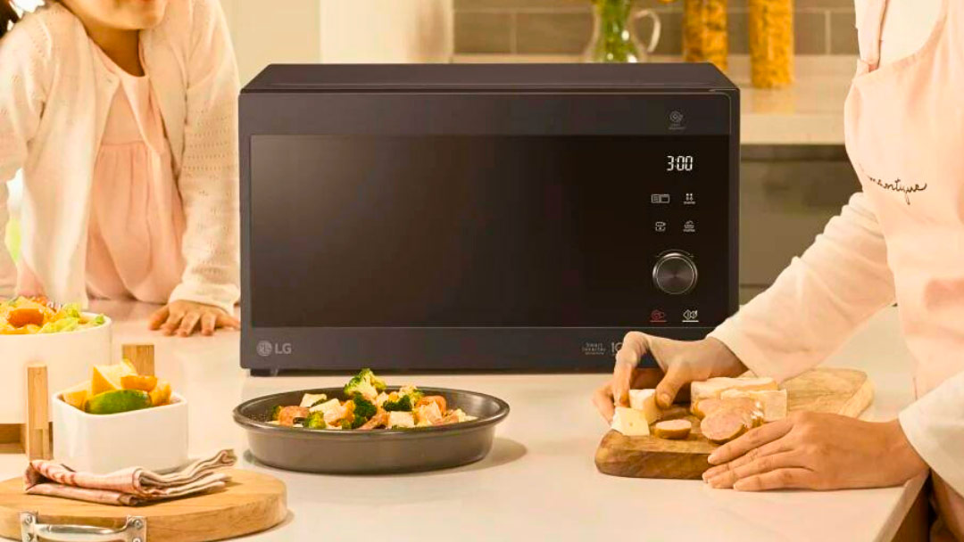 microondas Microondas ubicado en la encimera de la cocina junto a los alimentos