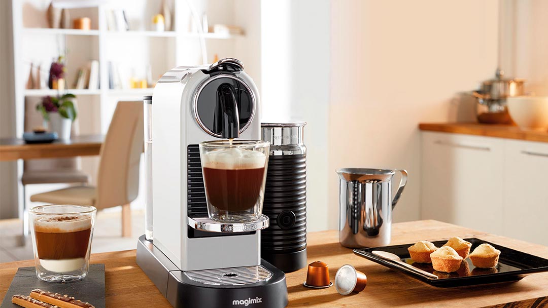 cafeteras-capsulas Una de las cafeteras de cápsulas en color blanco preparando cafés en la cocina