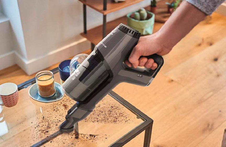 limpiando la mesa con uno de los accesorios de las aspiradoras escoba Rowenta