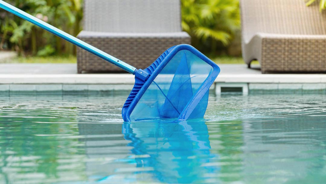limpiar-piscina limpiando la piscina con la ayuda de una red