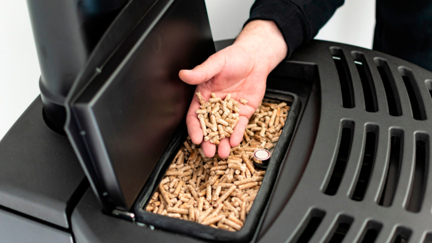 funcionamiento-estufa introducciendo pellets en el compartimento de la estufa
