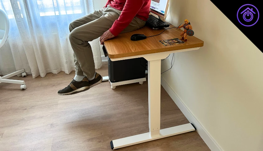 hombre sentado sobre el escritorio elevable Flexispot E1 Pro