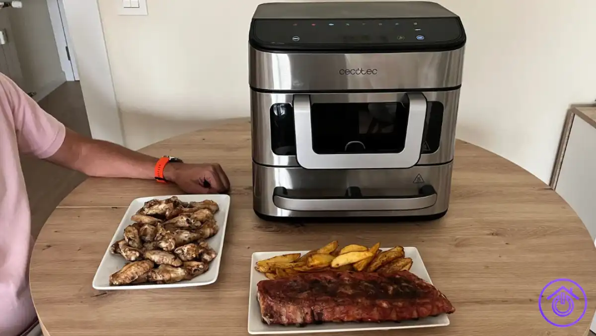 Dani junto a la Cecofry FoodCourt 18000 4Pizza con alitas, costillas y patatas preparadas durante nuestra prueba